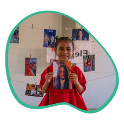 Niña mostrando orgullosamente una foto de su padrino, como parte del programa Sé Elegido de World Vision.
